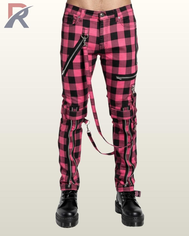Full front view of a male model wearing hot magenta pink and black buffalo plaid punk bondage pants with metal hardware straps.