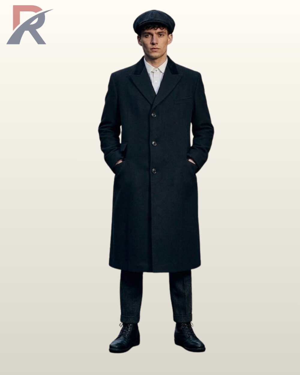 Full front view of a model wearing a buttoned men's black wool long overcoat featuring a black velvet collar accent, peak lapels, and newsboy cap.
