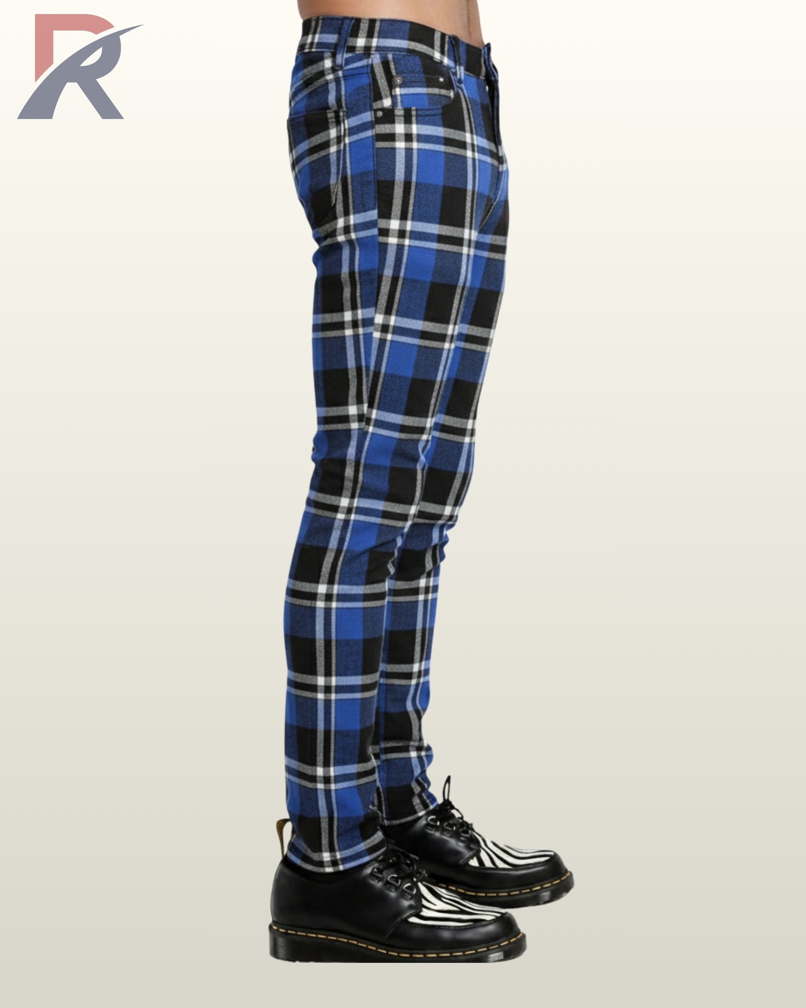 Side profile view of a model wearing men's cobalt blue, black, and white tartan plaid skinny punk trousers showing side seam pattern alignment.