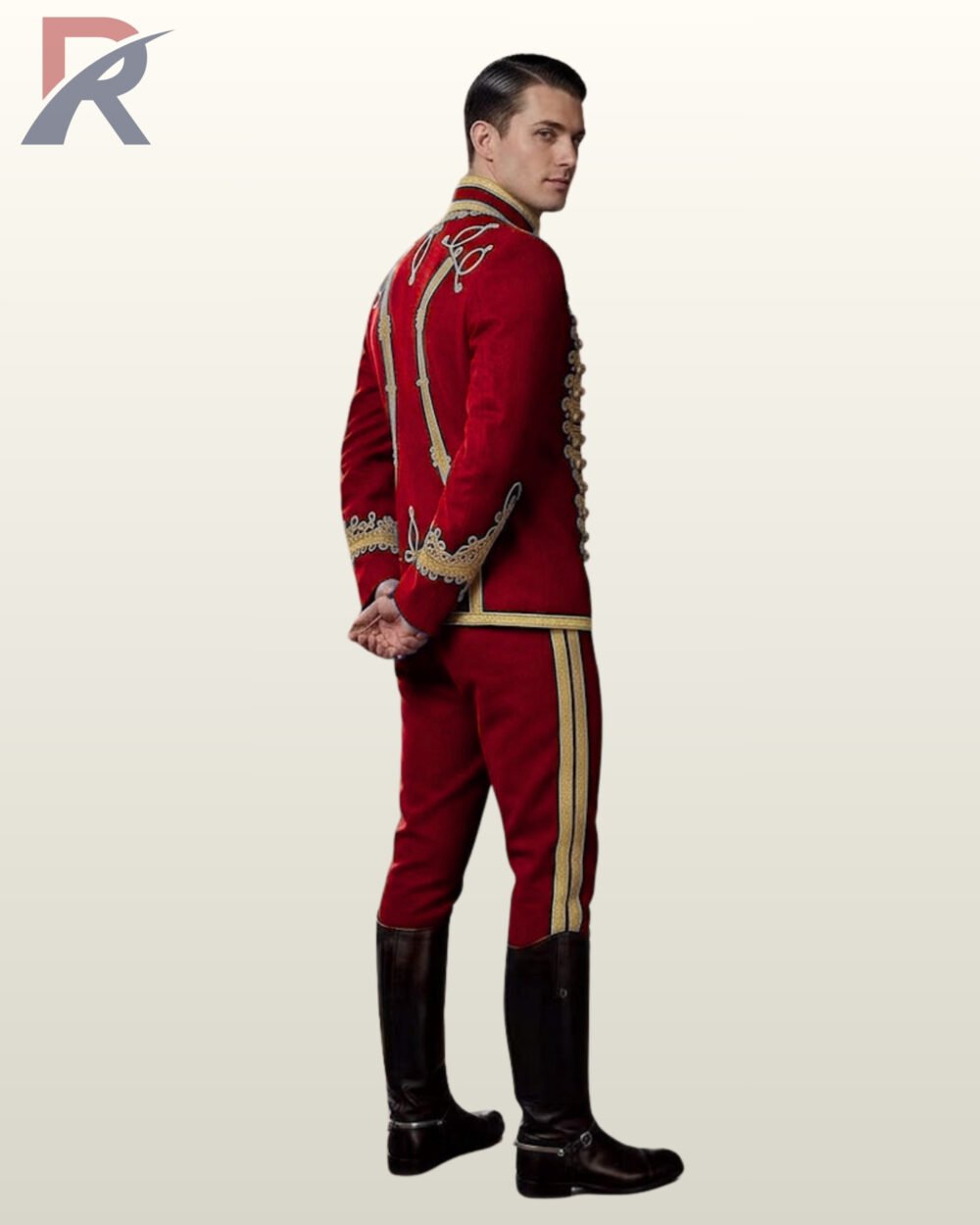 Side profile view of a model wearing a red military hussar uniform suit showing gold sleeve embroidery, cuff detailing, and dual gold trouser stripes.