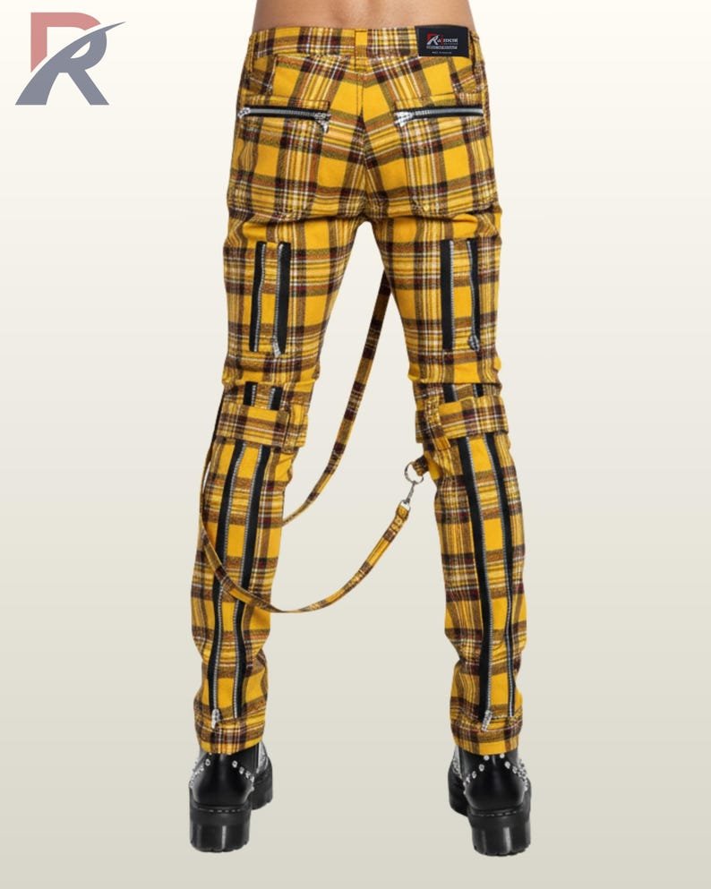 Back perspective of men's yellow and black checkered gothic trousers detailing silver back pocket zips, rear knee buckles, and platform leather boots.