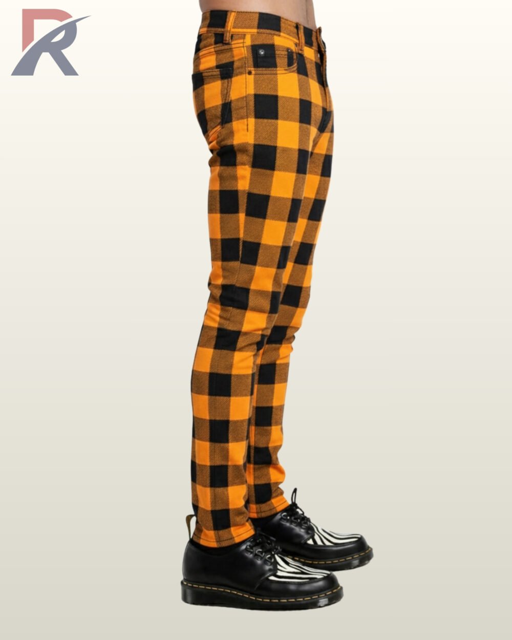 Slim-fit orange buffalo plaid men's trousers worn with black and white creepers.