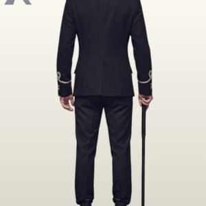 Full rear view of a model wearing a tailored black military hussar suit with silver collar embroidery, back vent split, and silver cuff loops, holding a black cane.