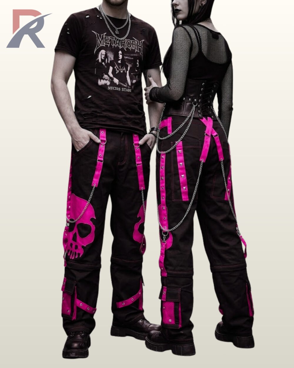 Gothic couple posing in wide-leg black cargo pants featuring high-contrast pink skull artwork.