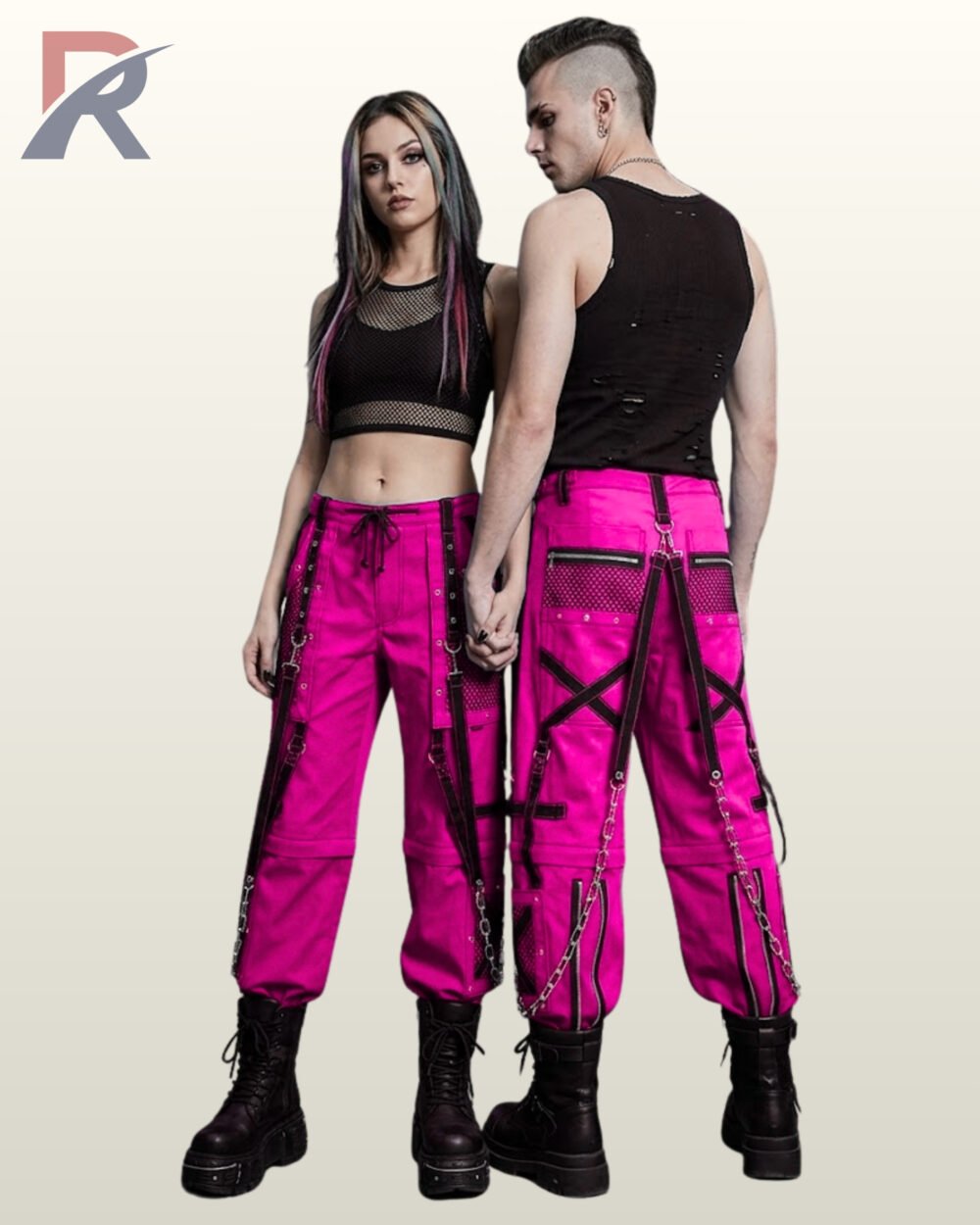 Man and woman posing in magenta hot pink techwear pants styled with black grommet straps and silver-tone chain accents.