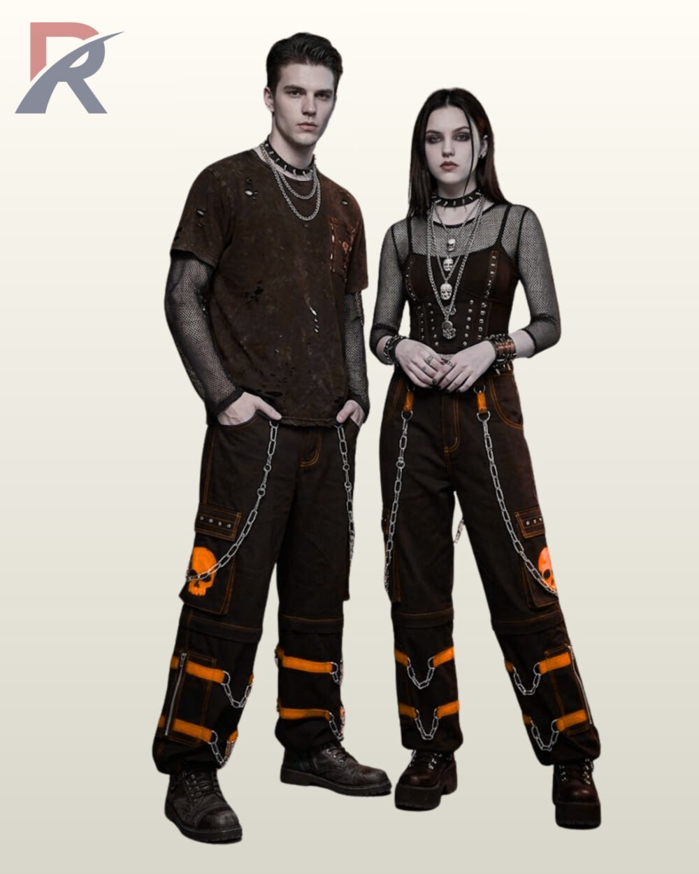 Full model view of a male and female wearing black gothic skull cargo pants with pumpkin orange contrast stitching, orange skull graphics, and metal chains.