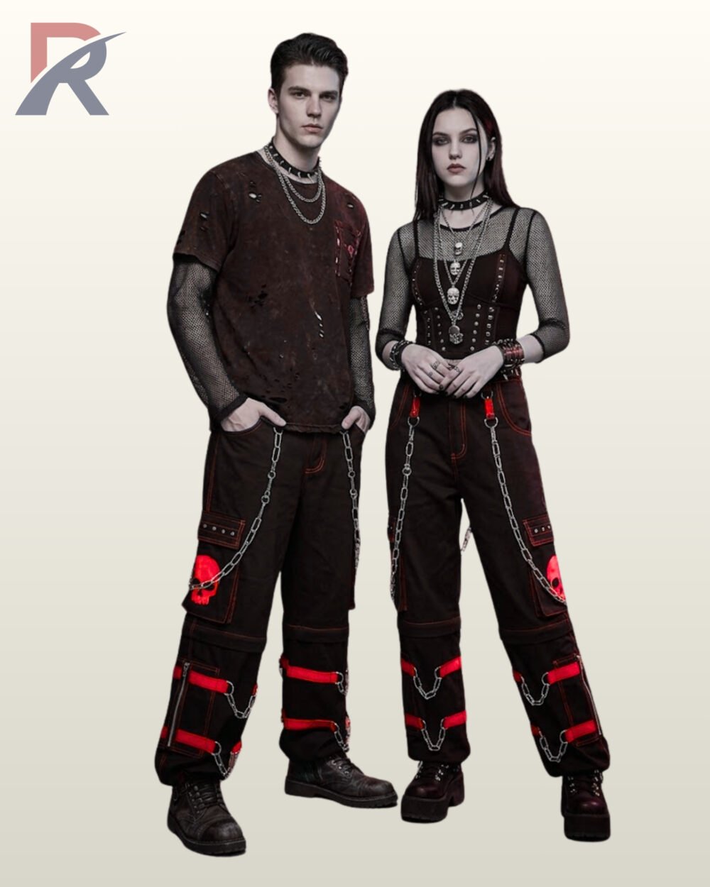 Full model view of a male and female wearing black gothic skull cargo pants with bold crimson red contrast stitching, red skull patch pockets, and metal chains.