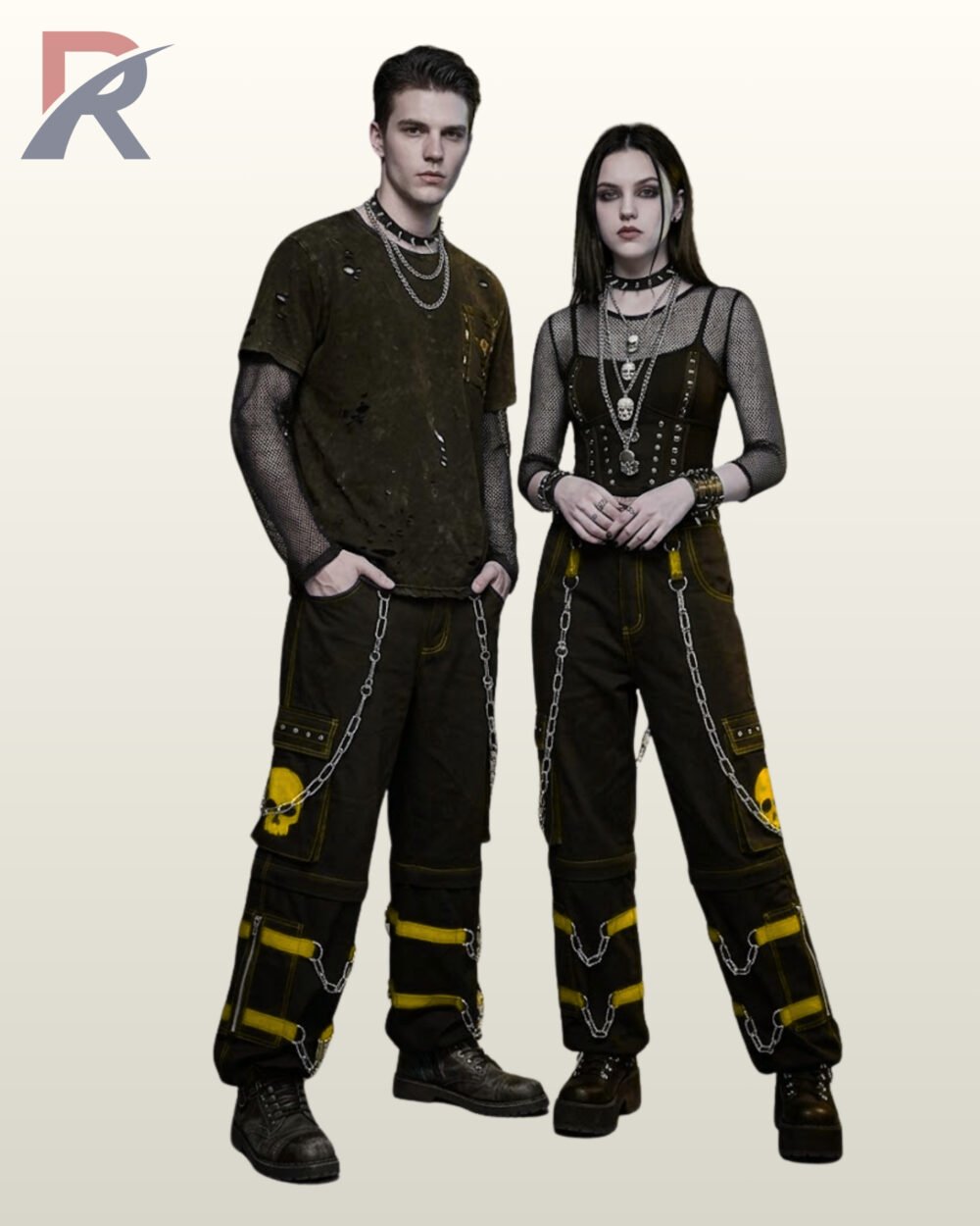 Couples model display of loose-fit black cyberpunk cargo trousers featuring yellow buckle straps, leg zippers, hanging silver chains, and skull print pockets.