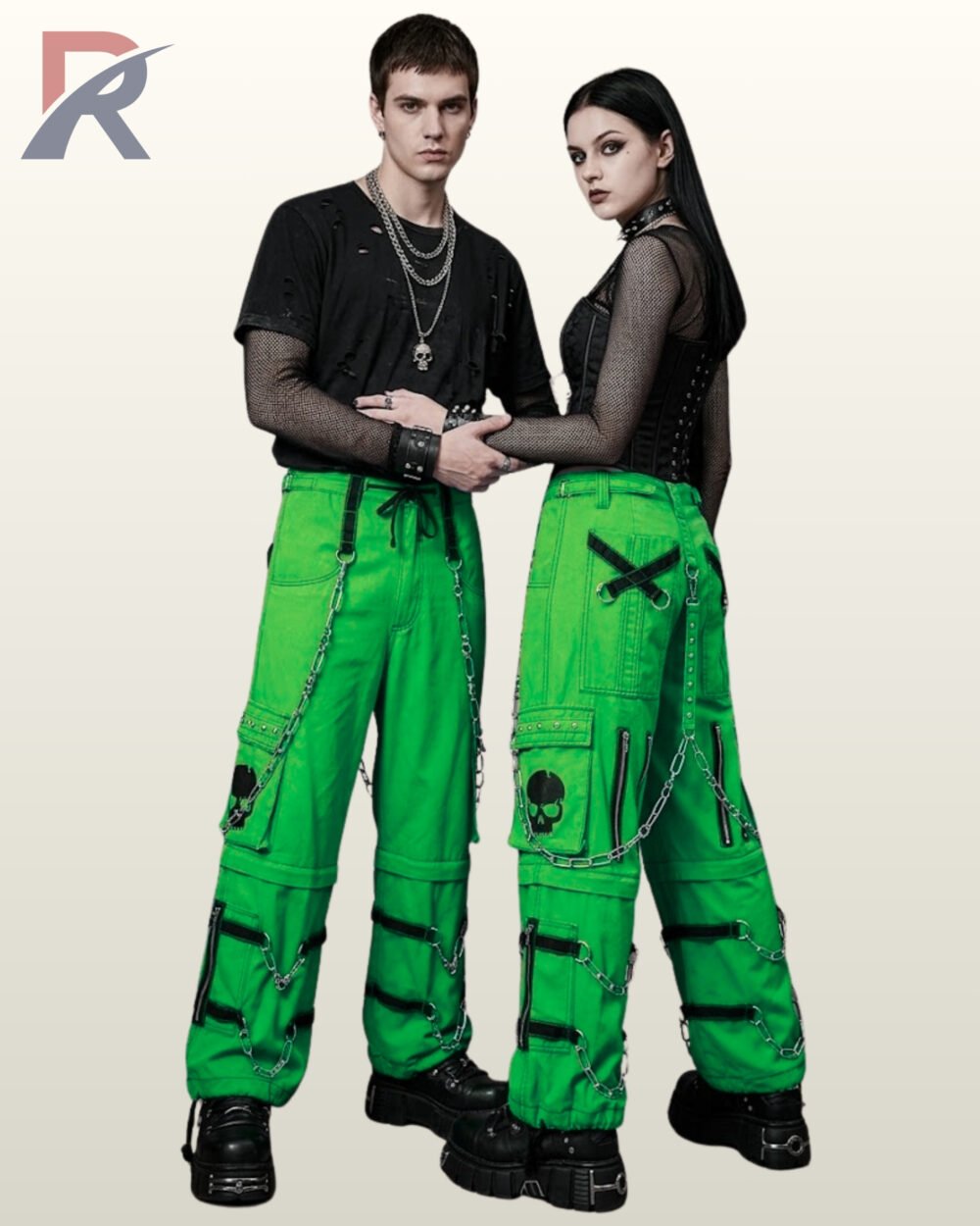 Couples catalog display of baggy bright green cyberpunk cargo pants featuring black skull graphics, leg zipper accents, hanging chains, and platform footwear.