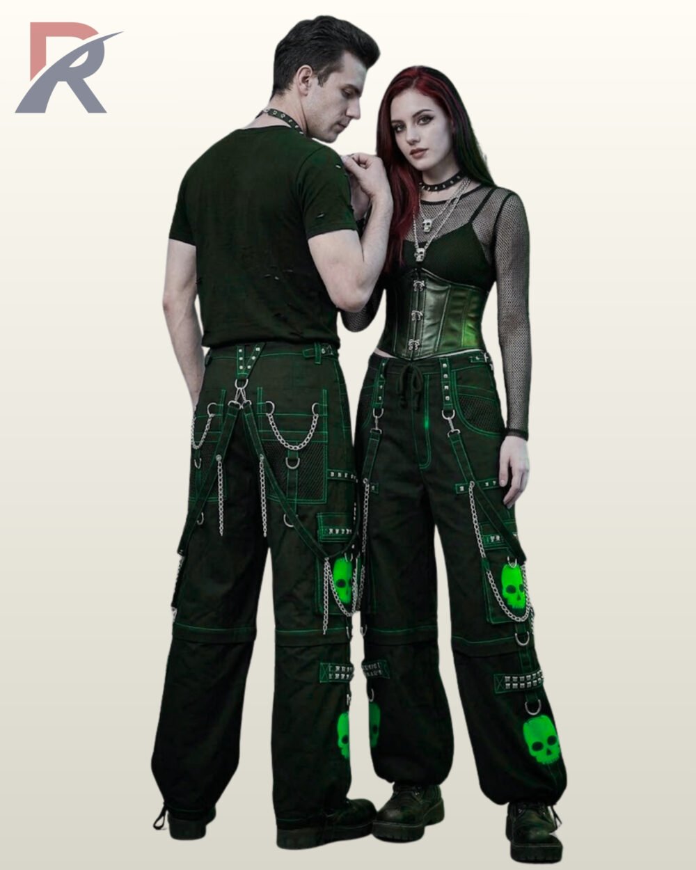 Couple wearing matching black gothic cargo pants featuring neon green contrast stitching, skull graphics, and metal chain straps.