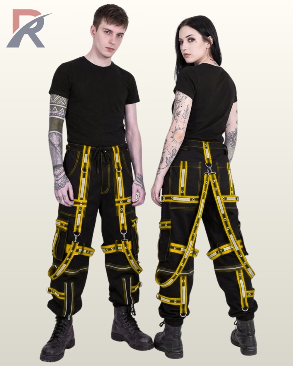Couple wearing black gothic cargo joggers trimmed with bright yellow reflective eyelet straps and suspender details.