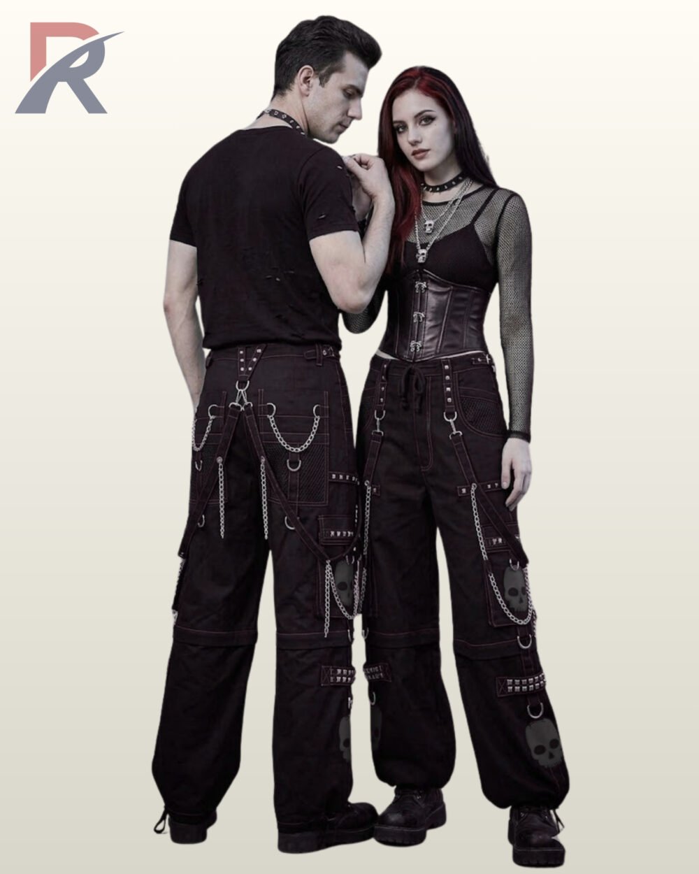 Man and woman modeling dark monochrome techwear pants featuring grey skull motifs and silver chain accents.
