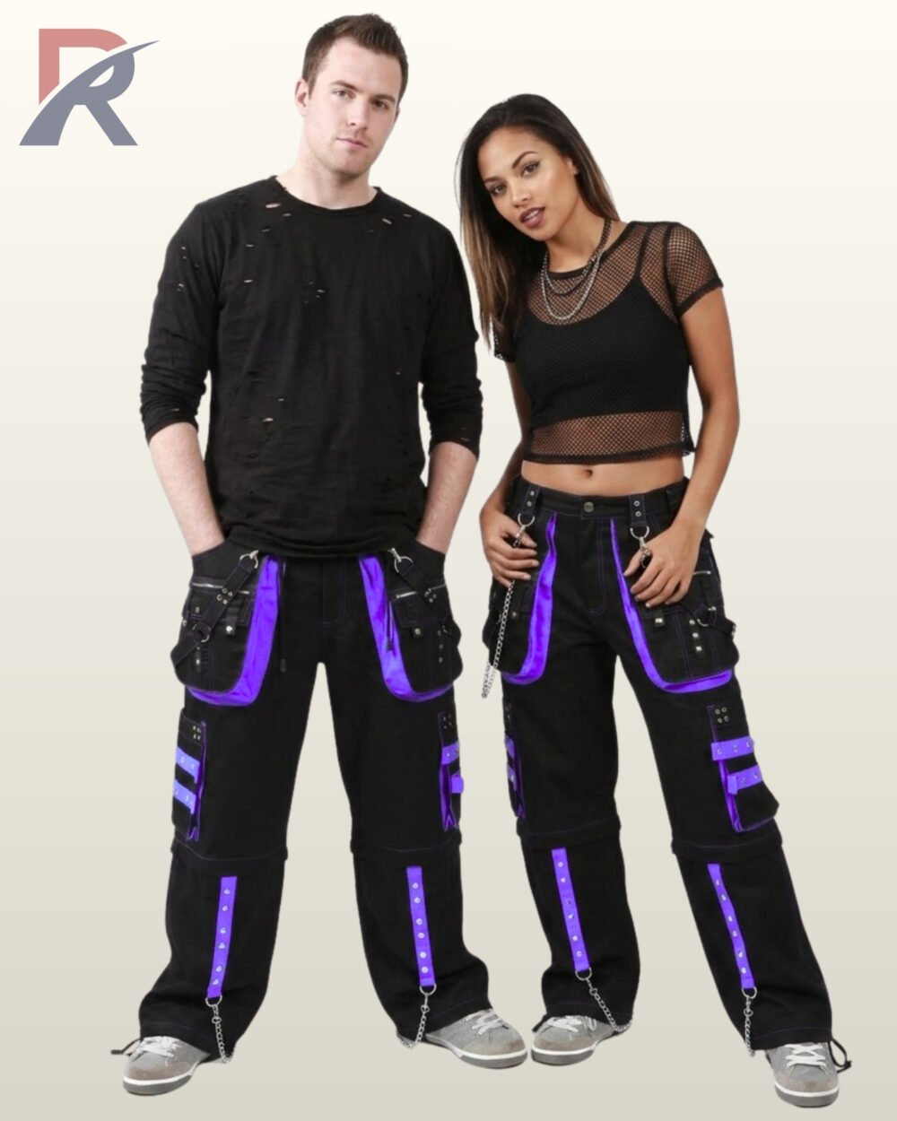 Front view of a couple posing in matching black gothic wide-leg cargo pants featuring purple trim, metal studs, and hanging chains.