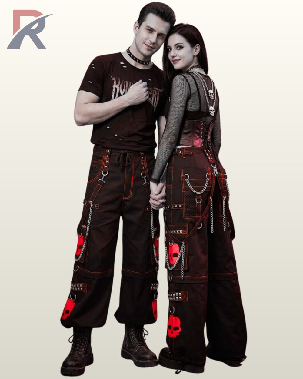 Man and woman modeling wide-leg industrial goth trousers with red skull graphics and hanging silver-tone chains.