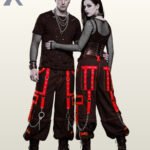 Alternative fashion couple wearing baggy black punk trousers styled with red trim and metallic accents.
