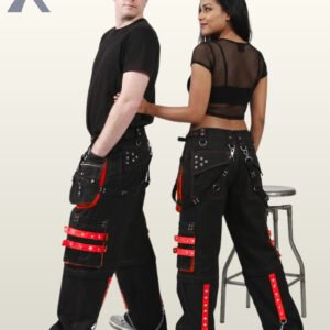 Side and back view of a couple wearing black gothic cargo pants trimmed with red studded straps, detachable pockets, and metal chains.