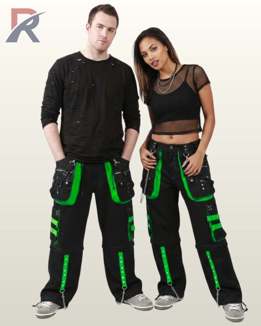 Man and woman modeling wide-leg cyber goth techwear pants featuring neon green studded details and silver chain hardware.
