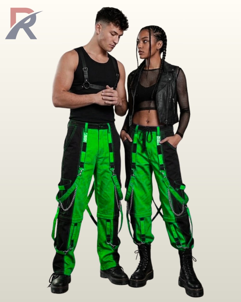 Couples model view of two-tone green and black cyberpunk cargo trousers featuring bright neon panels, side metal chains, and platform combat boots.