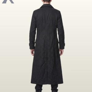Full rear view of a male model wearing a floor-length black gothic trench coat displaying tailored back seams, high standing collar back, and center skirt split.