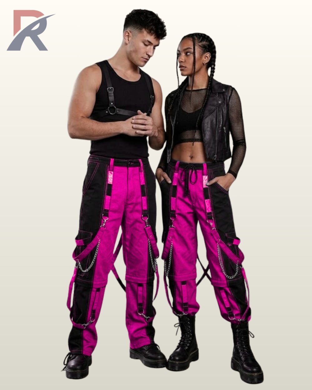 Couples model shot of two-tone neon pink and black cyberpunk raver cargo trousers featuring hanging leg straps, side metal chains, and platform boots.