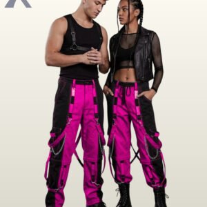 Couples model shot of two-tone neon pink and black cyberpunk raver cargo trousers featuring hanging leg straps, side metal chains, and platform boots.
