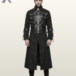 Full front model view of a man wearing a black gothic trench coat featuring a prominent faux leather skull chest plate, chest buckles, multi-strap waist belt, and lace-up sleeves.
