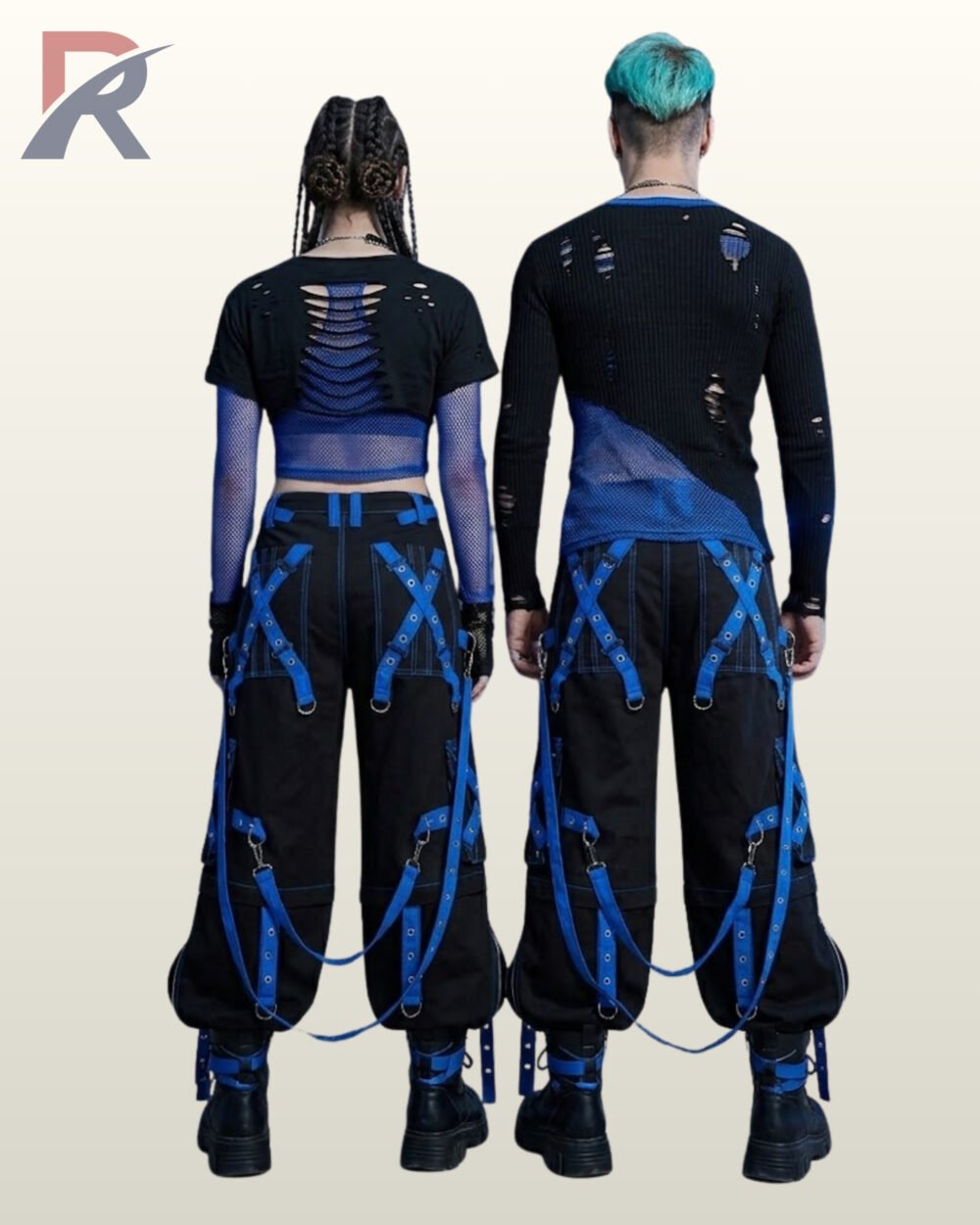 Couples model view of baggy black gothic raver trousers displaying cobalt blue metal-eyelet leg straps, hanging bondage straps, and black leather boots.