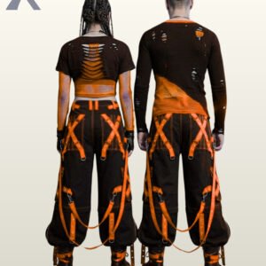 Couples model shot of baggy black gothic raver trousers with vibrant orange metal-eyelet leg straps, hanging D-ring straps, and platform combat boots.