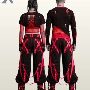 Couples catalog shot of baggy black gothic raver trousers displaying neon red metal-eyelet leg straps, zipper thigh pockets, and black combat boots.