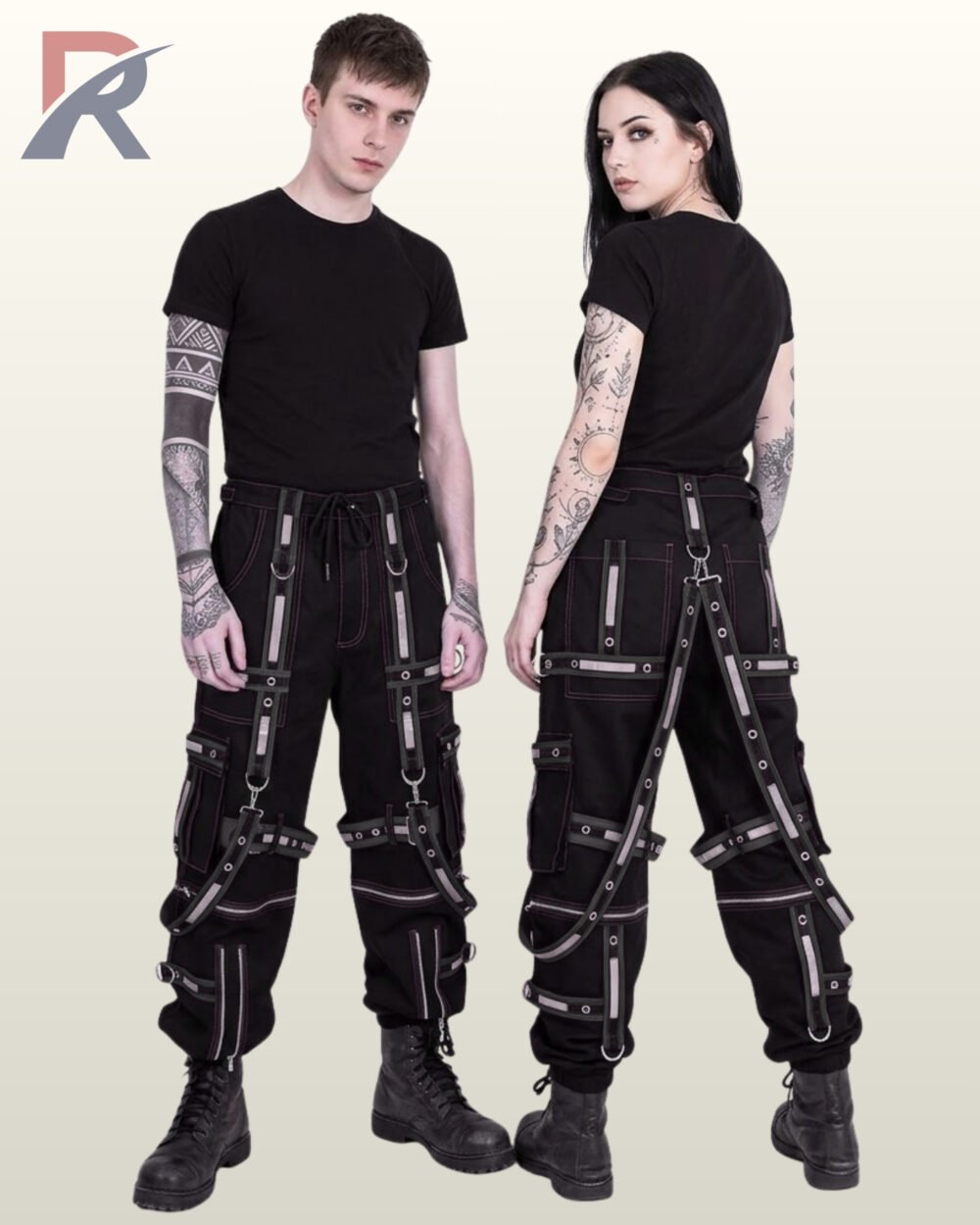 Man and woman posing in all-black cyberpunk techwear joggers styled with reflective trim and silver metal hardware.