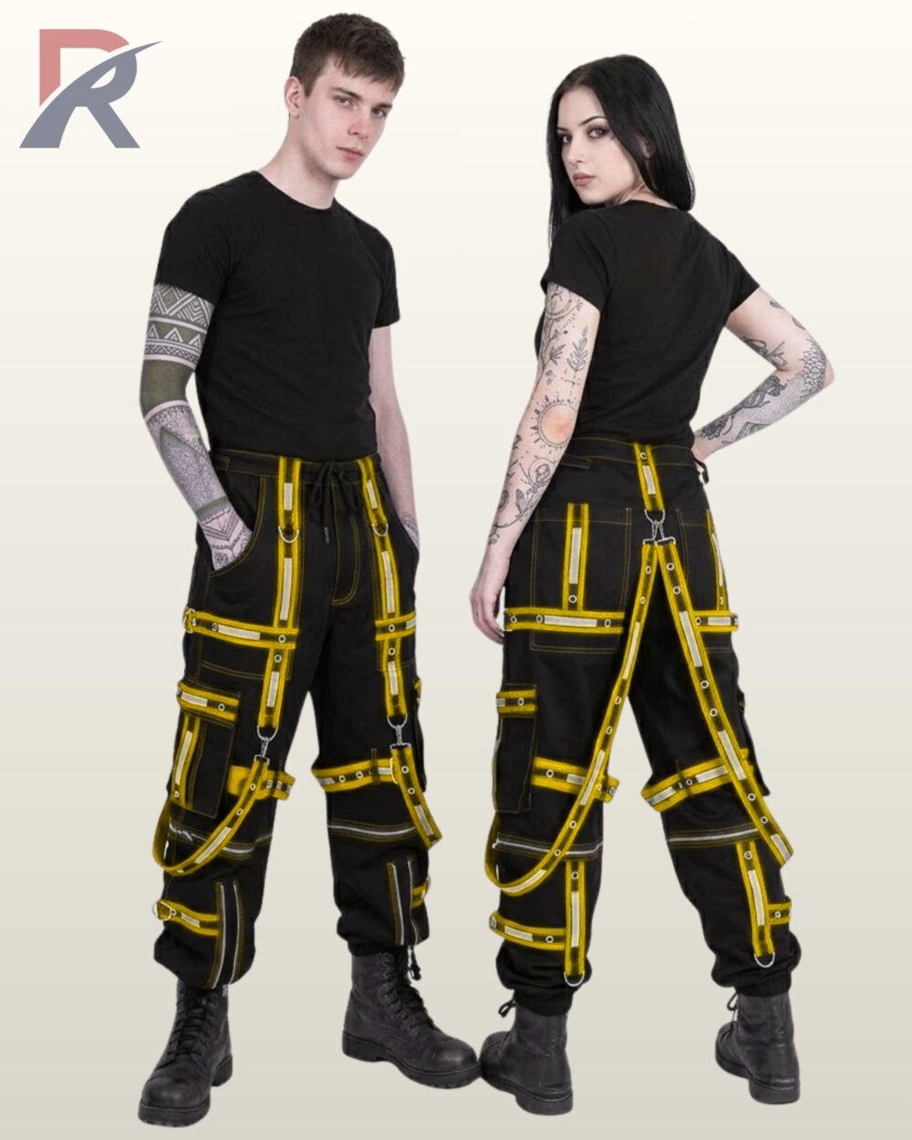 Man and woman posing in cyberpunk wide-fit trousers featuring bright yellow high-visibility reflective straps and metal rings.