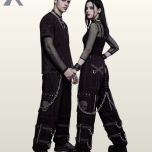 Couples model shot of all-black gothic cyberpunk cargo trousers displaying subtle grey skull pocket graphics, black buckle leg straps, and silver chains.