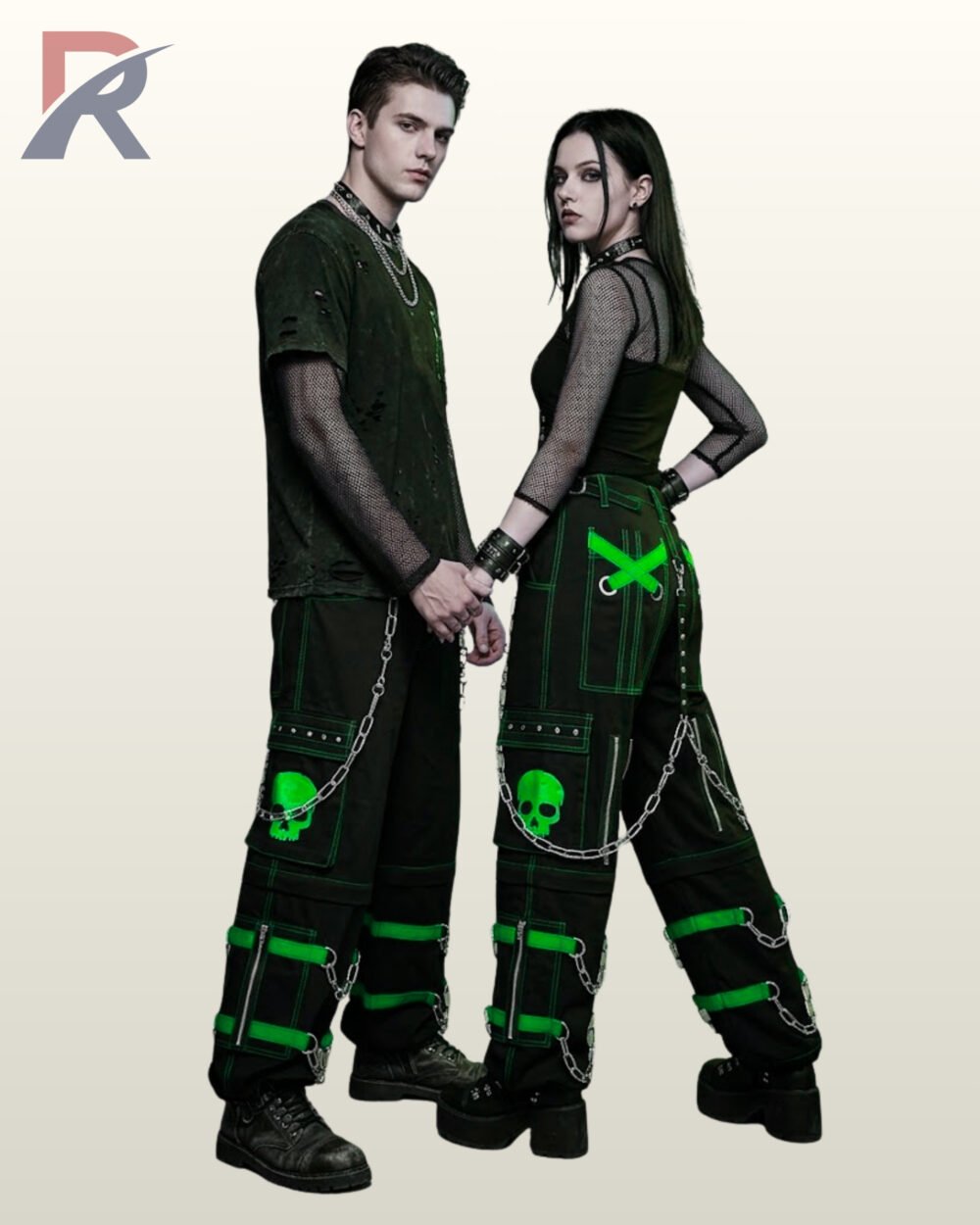 Couples catalog display of black cyberpunk cargo trousers featuring toxic neon green buckle leg straps, skull graphics, hanging silver chains, and platform boots.