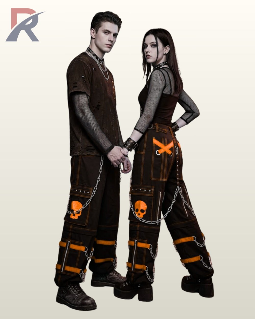 Couples catalog display of black cyberpunk cargo pants featuring bright orange buckle leg straps, skull patch pockets, and hanging silver side chains.