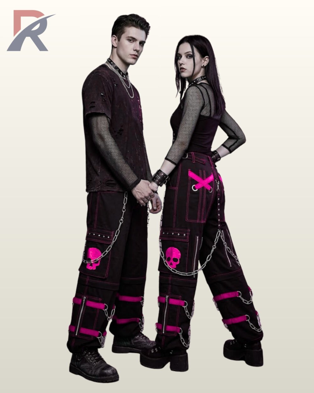 Full model view of a male and female wearing black gothic skull cargo pants with bright magenta pink contrast stitching, pink skull patch pockets, and metal chains.