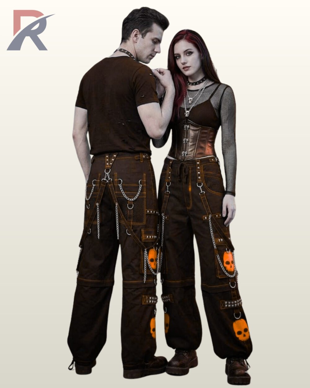 Couple wearing alternative streetwear trousers accented with orange skull prints and hanging metal chains.