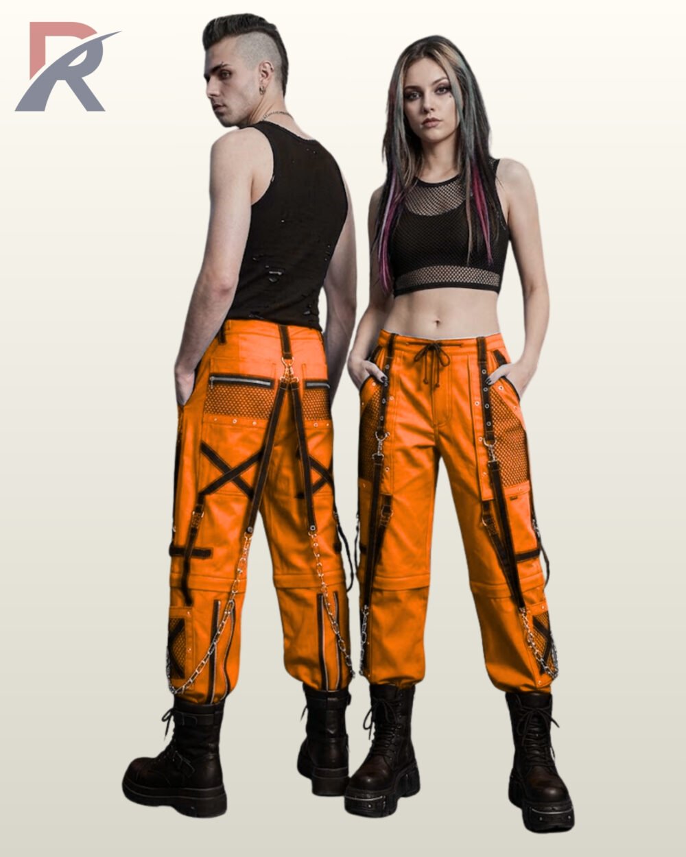Couple wearing bright orange gothic cargo pants detailed with black mesh trim, cross straps, and hanging metal chains.