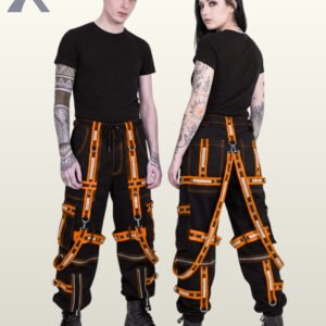 Couple in black gothic cargo pants styled with bright orange reflective straps, grommeted trim, and suspender harnesses.