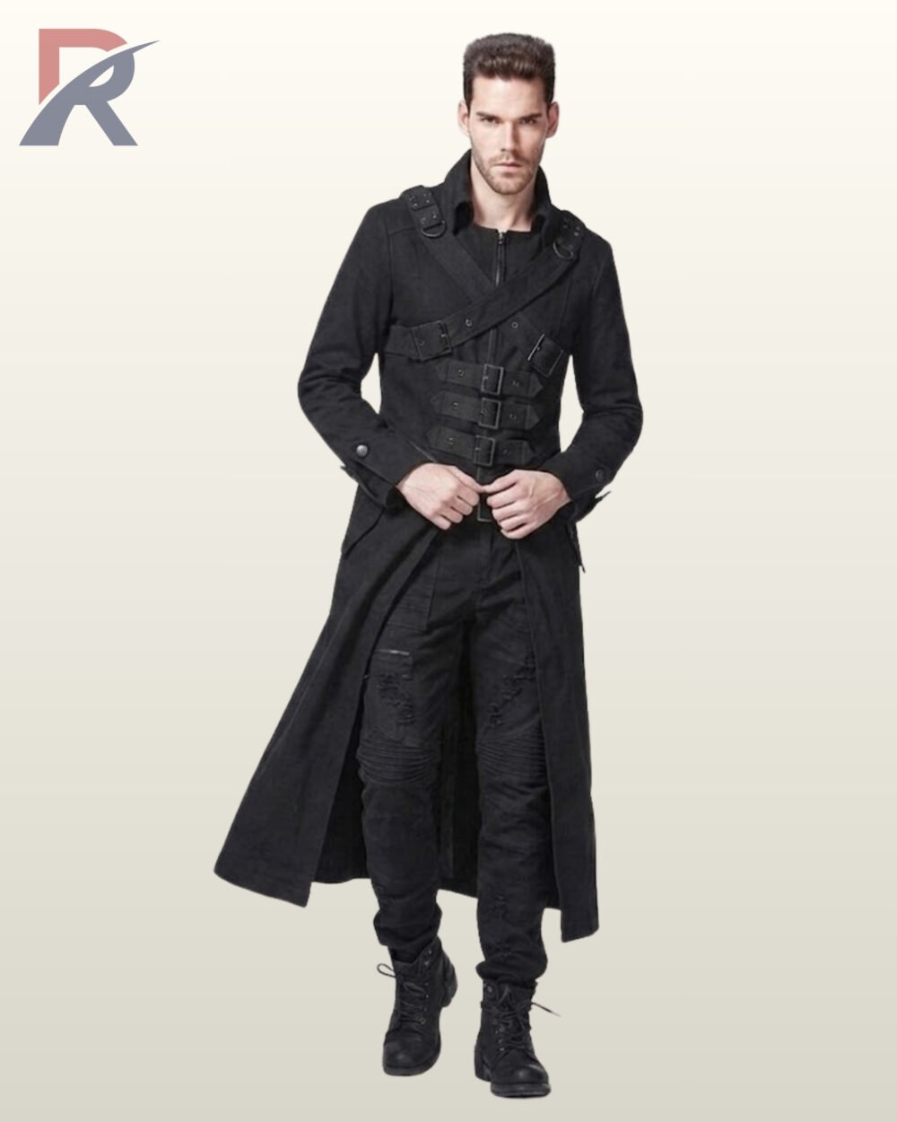 Male model standing in a floor-length black steampunk overcoat displaying cross-body buckle straps, distressed denim trousers, and black combat boots.
