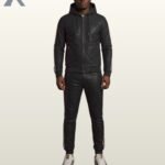 A man modeling a classic black leather hooded tracksuit with subtle white side stripes.