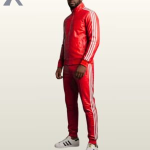 A full-length view of a man modeling a vibrant red leather tracksuit with classic white athletic stripes.