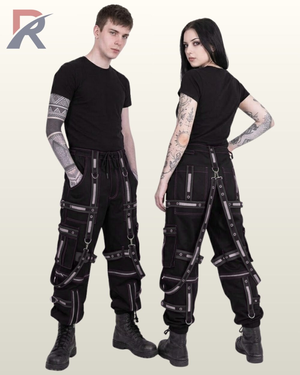 Couple wearing black gothic cargo trousers featuring reflective silver straps, metal eyelets, and detachable suspender harnesses.