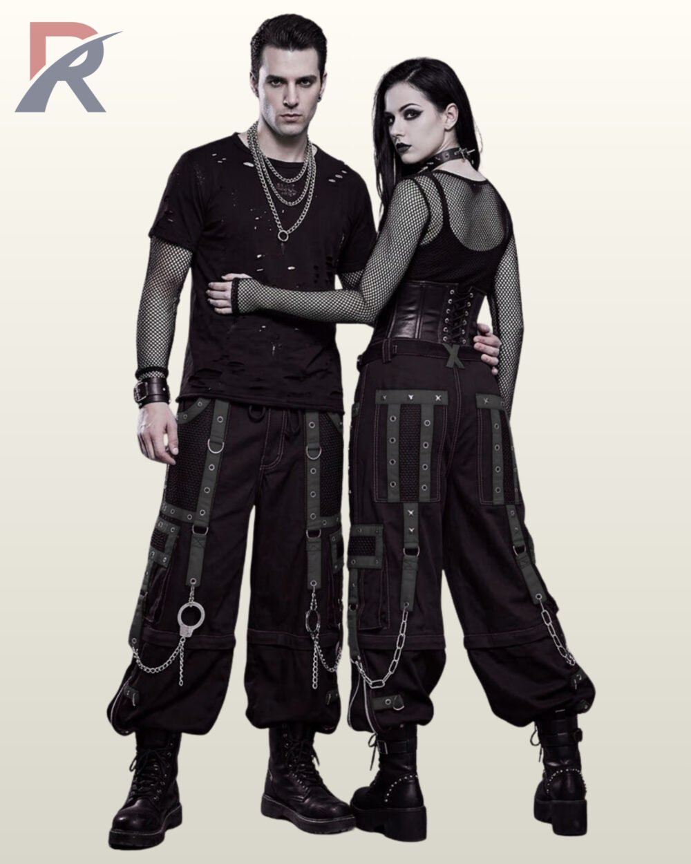 Man and woman styled in dark black gothic cargo pants contrast webbing and metal chains.