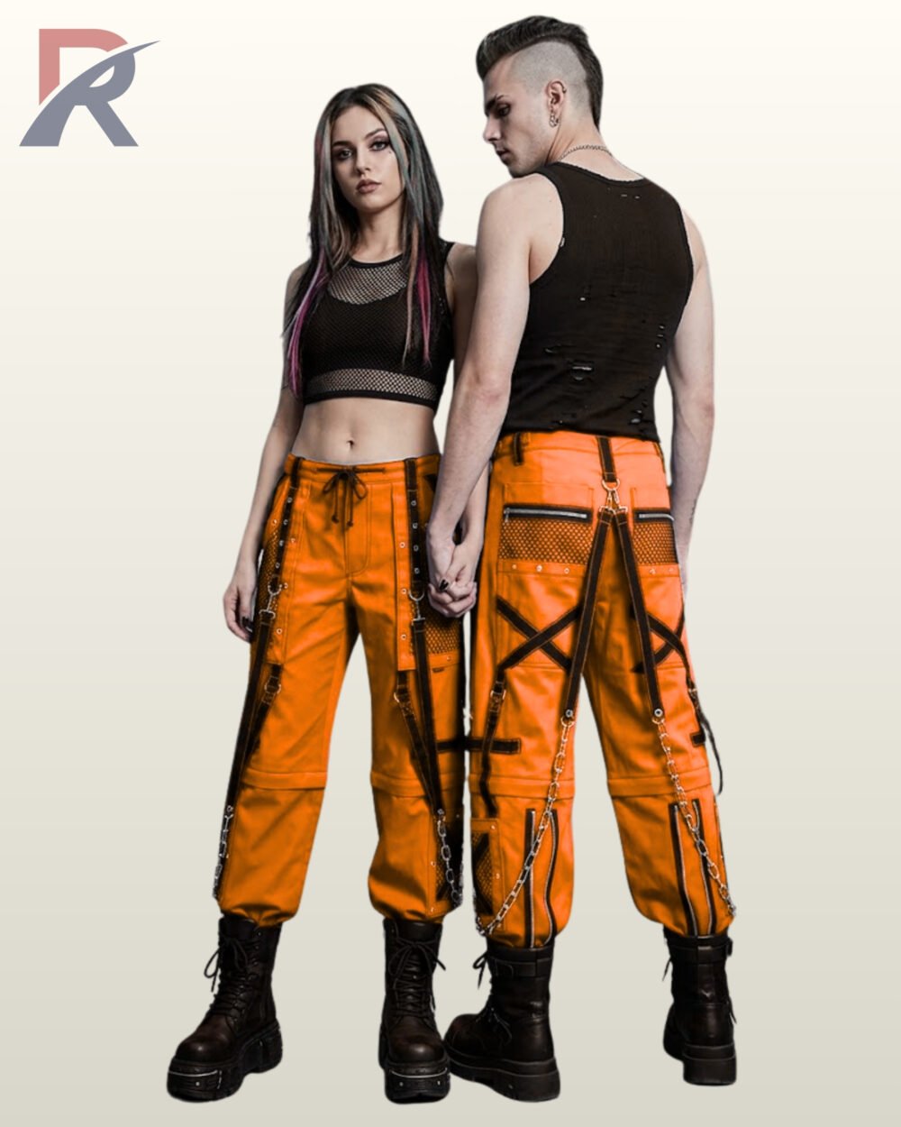 Man and woman modeling orange cyber goth trousers accented with black bondage straps, eyelets, and silver metal chains.