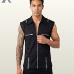 Full front model view of a men's black sleeveless gothic biker vest featuring a full zip front, metallic shoulder zippers, chest pockets, and waist zips.