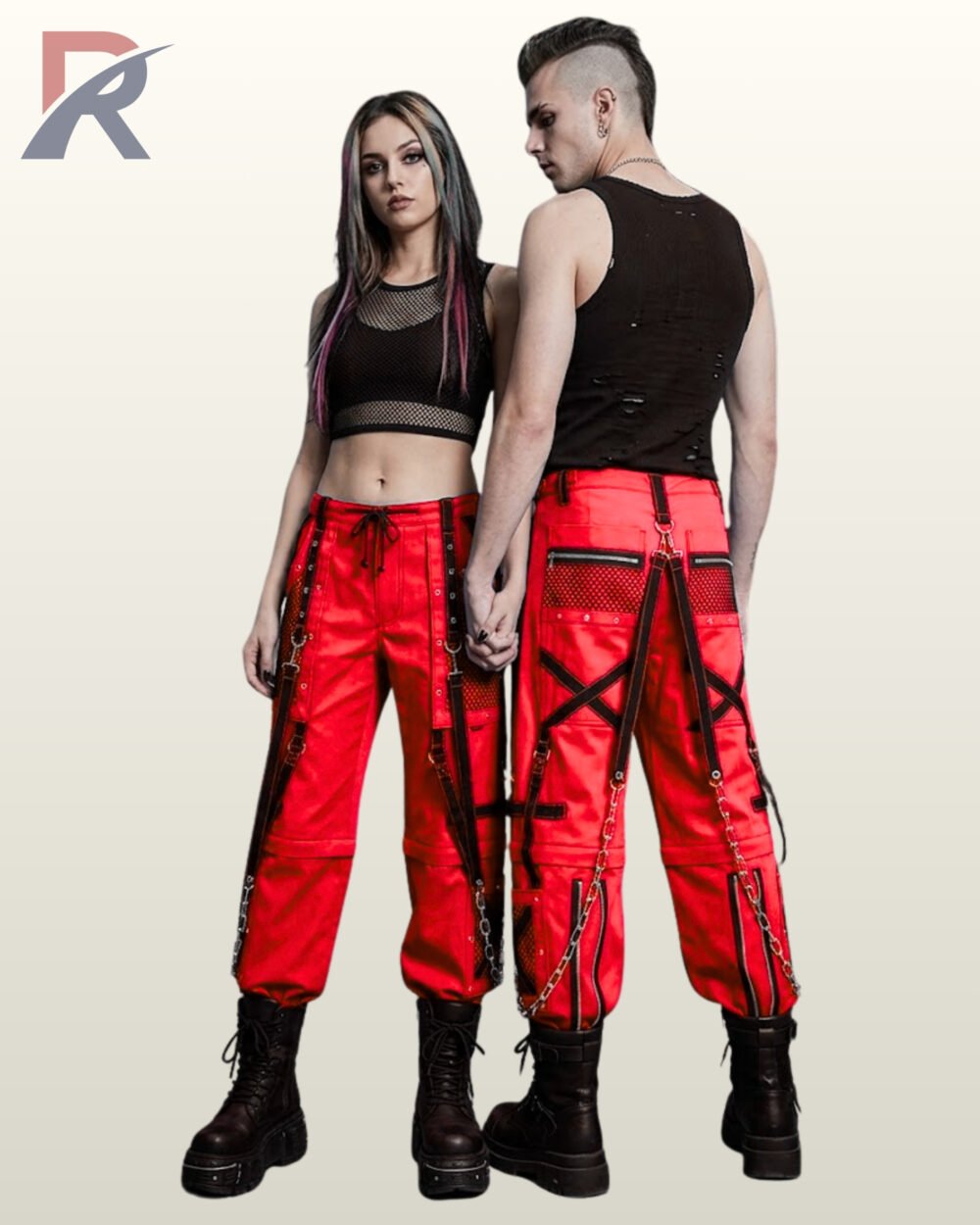 Couple wearing bold red gothic cargo pants with black mesh panels, eyelet straps, and silver chain details.