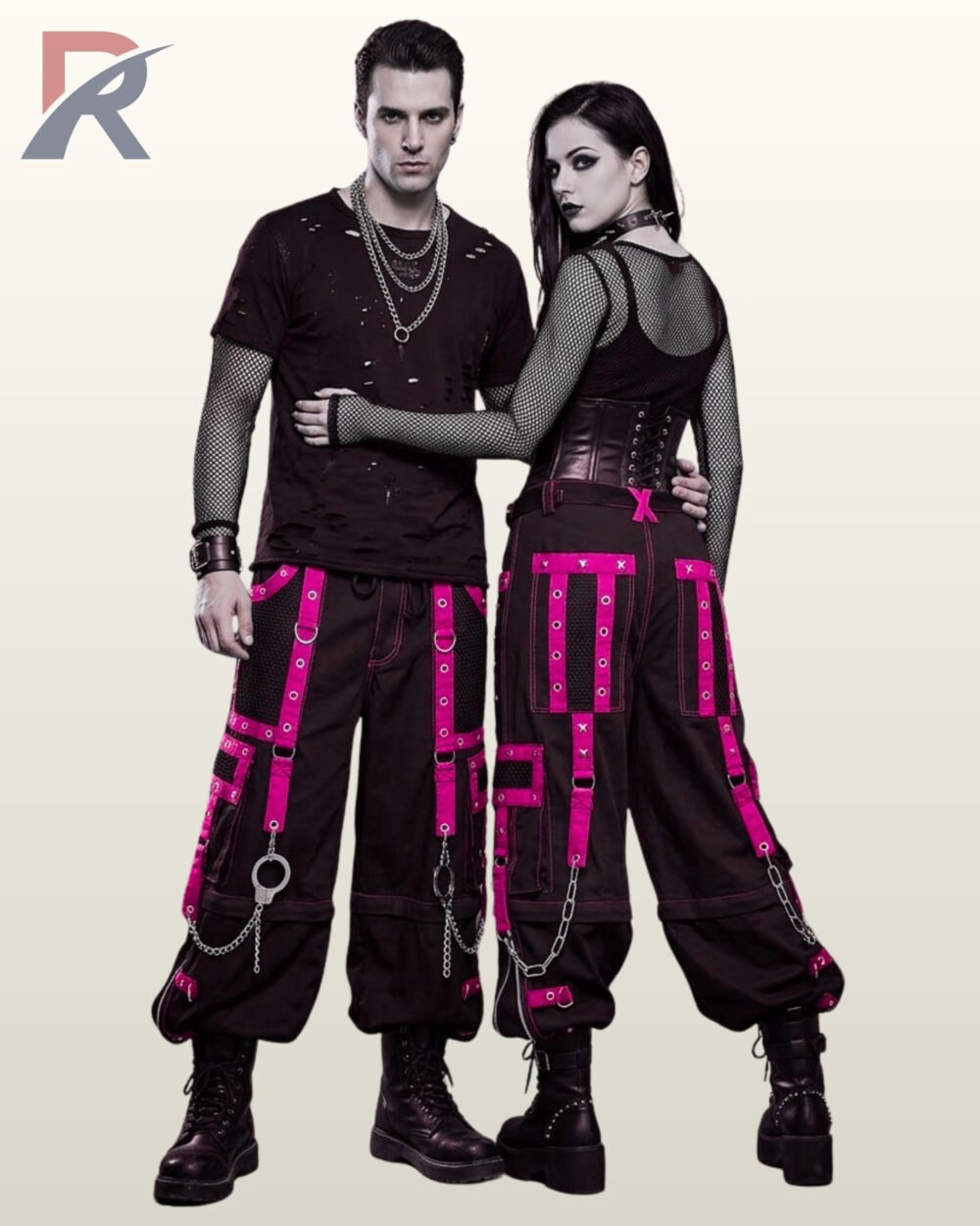 Gothic couple posing in baggy black cargo trousers featuring hot pink eyelet straps and silver chains.