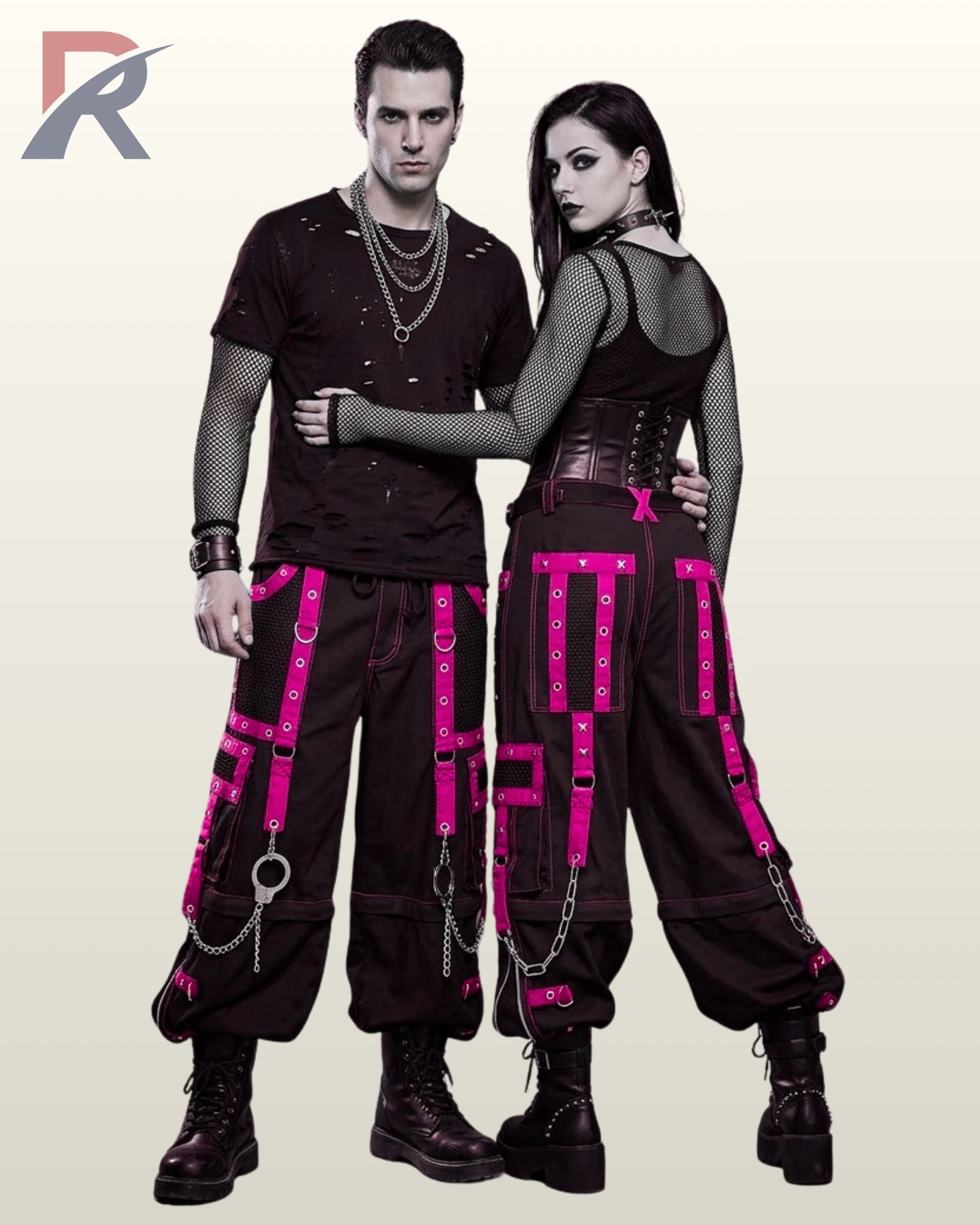Gothic couple posing in baggy black cargo trousers featuring hot pink eyelet straps and silver chains.