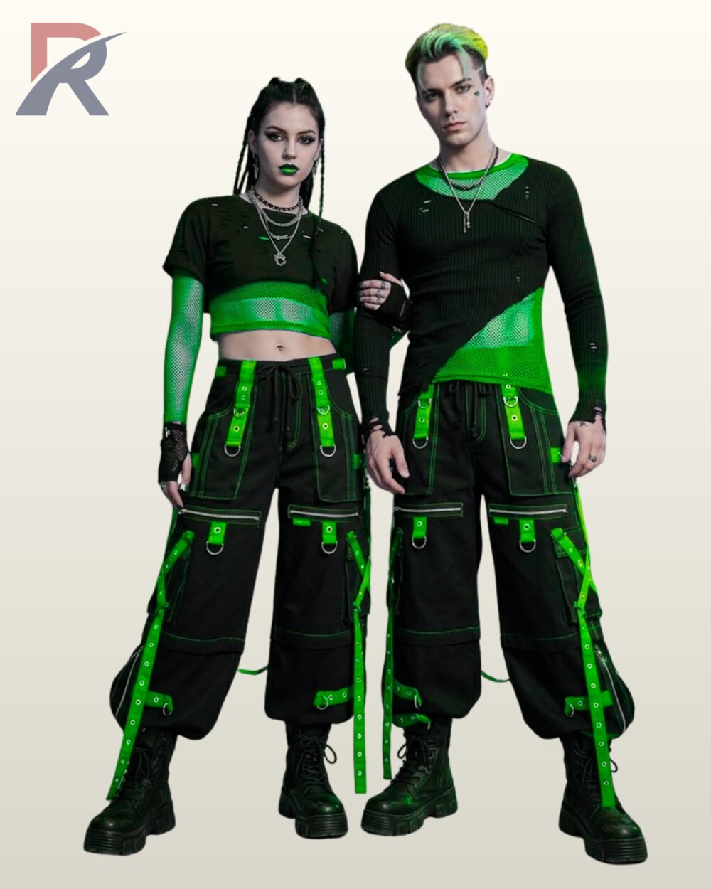 Full front model view of a couple wearing black cyberpunk cargo pants with toxic neon green grommet straps, zip thigh pockets, and contrast green stitching.