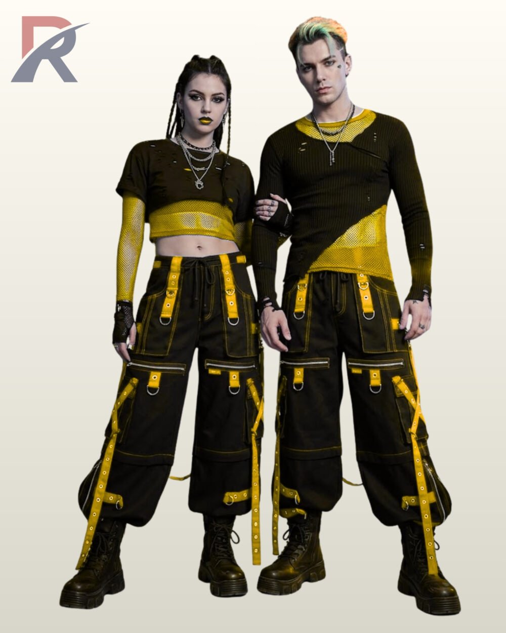 Full front model view of a male and female wearing black cyberpunk cargo pants featuring bright yellow grommet straps, contrast yellow stitching, and D-ring hardware.